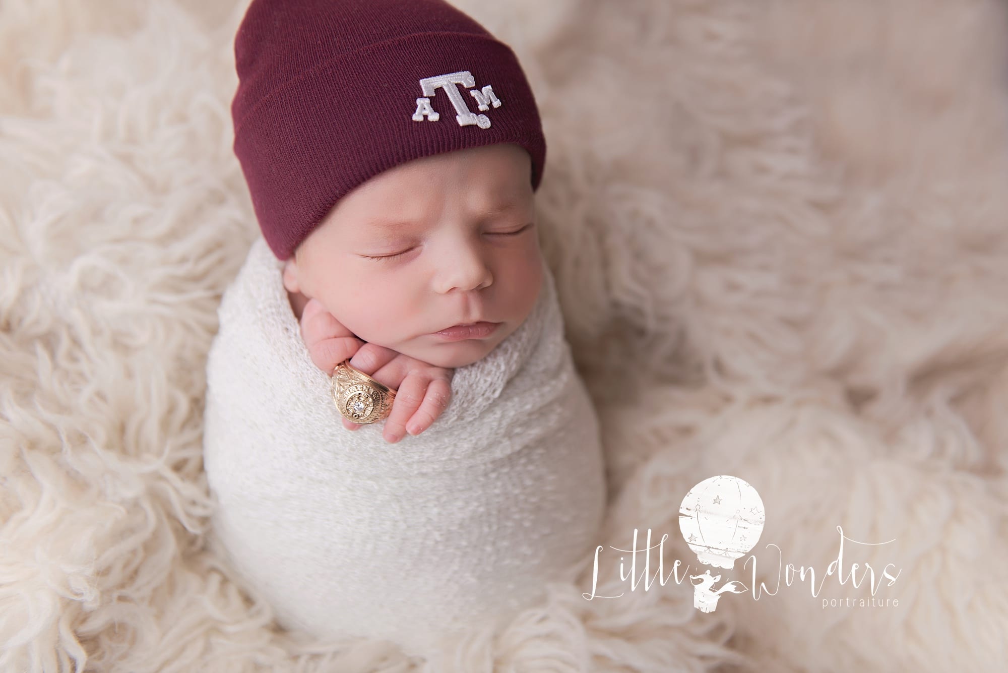baby with a&m hat and dads ring